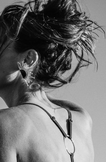 Rhea Bikini 29 Elegant RHEA black triangle bikini with eco raffia detailing model poses confidently on coastal rocks at golden hour